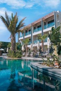 a hotel with a swimming pool and palm trees at Rammos Managed By Dedeman in Bodrum City