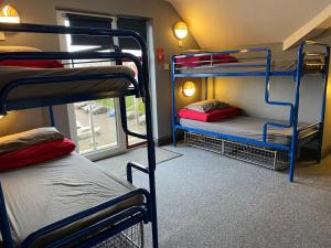 a room with three bunk beds and a window at Sleepzone Hostel Galway City in Galway