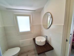 a bathroom with a toilet and a sink and a mirror at Casa Vacanze Spiaggia Playa in Castellammare del Golfo