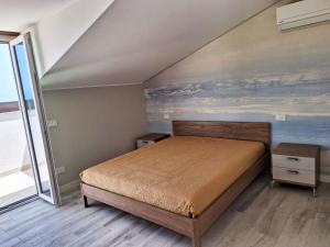カステッランマーレ・デル・ゴルフォにあるCasa Vacanze Spiaggia Playaのベッドルーム1室(ベッド1台付)が備わります。壁には絵画が飾られています。