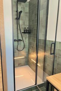 um chuveiro numa casa de banho com azulejos verdes em Appartment Alpenrose em Saas-Fee
