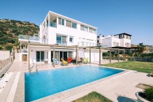 a villa with a swimming pool in front of a house at Chic Villa w Patio Pool 3 min to Beach in Bodrum in Gundogan