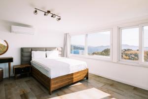 Dormitorio blanco con cama y ventanas en Chic Villa w Patio Pool 3 min to Beach in Bodrum en Gundogan