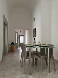jadalnia ze stołem z krzesłami i kieliszkami do wina w obiekcie Guest House tra Terra e Mare w mieście Pachino