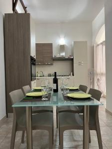 a dining room table with chairs and a bottle of wine at Guest House tra Terra e Mare in Pachino