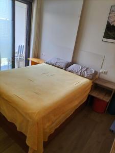 ein großes Bett in einem Zimmer mit Fenster in der Unterkunft Рядом с пляжем, тихое место in Alicante
