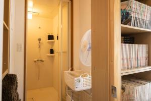 a room with a closet with a fan on a shelf at Bed&Cafe Onzo オンゾー in Onomichi