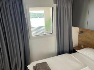 - une chambre avec un lit et une fenêtre dans l'établissement Bella Homes Camping, à Tisno