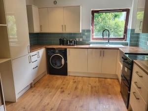 a kitchen with a sink and a washing machine at Kinlochleven Holiday Home in Kinlochleven