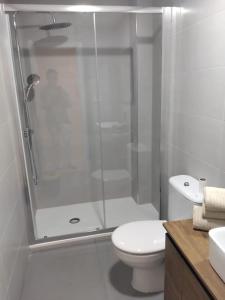 a white bathroom with a shower and a toilet at Piso exclusivo en Getafe centro in Getafe