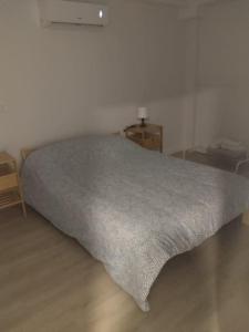 a bedroom with a bed with a gray blanket on it at Piso exclusivo en Getafe centro in Getafe