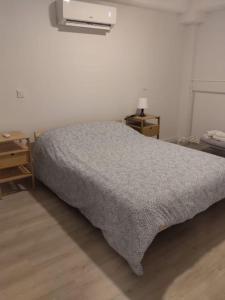 a bedroom with a bed with a gray blanket at Piso exclusivo en Getafe centro in Getafe