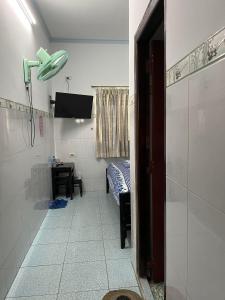 a bathroom with a room with a bed and a shower at Cát Phượng Motel in Phan Thiet