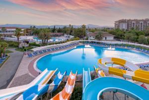 una piscina en un complejo con sillas y toboganes en Euphoria Palm Beach Resort, en Kizilagac