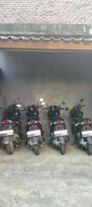 een groep motorfietsen geparkeerd onder een gebouw bij Tara hostel in Nusa Penida