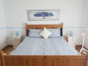 Un dormitorio con una gran cama de madera con almohadas azules en ViVaTenerife - Retreat in nature, SPA and wellness, en Tejina de Isora