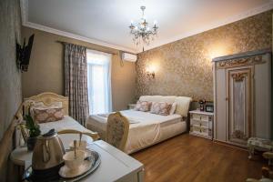Borjomi Classic Hotel في بورجومي: غرفة نوم بسريرين وثريا