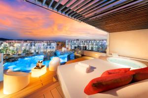 a bedroom with a large window with a bath tub at Hard Rock Hotel Ibiza in Playa d'en Bossa