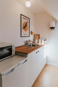 a kitchen with a sink and a microwave at KEFS Guesthouse & Café in Ærøskøbing