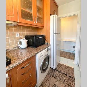 a kitchen with a washing machine and a microwave at Sweet Flat For Sweet Famılies in Istanbul