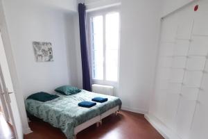 een klein bed in een kamer met een raam bij Bienvenue in Auxerre