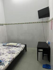 a room with a bed and a table with a tv at Cát Phượng Motel in Phan Thiet