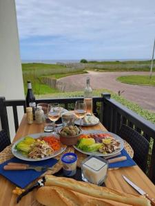una mesa con dos platos de comida y copas de vino en Joli studio près du front de mer, en Cabourg
