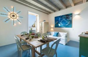 ein Esszimmer mit einem Tisch, Stühlen und einem Sofa in der Unterkunft Dimora del Sole Luxury and charm apartment in Otranto