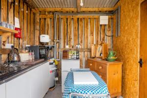 a kitchen with wooden walls and a table in a room at Shepherds Hut at The Retreat in Oswestry