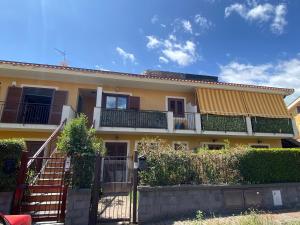 a yellow house with stairs and balconies on it at CASA VACANZA DAMAR in Mascali