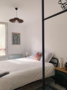 een slaapkamer met een wit bed met een zwarte paal bij Au nom de la rose, beau 3 pièces en centre-ville in Provins
