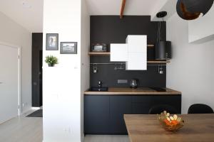 uma cozinha com paredes em preto e branco e uma mesa em Bright attic flat in the centre em Riga