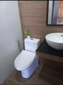 a bathroom with a white toilet and a sink at Yannas transient house in Roxas City