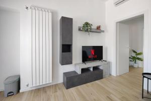 a living room with a tv on a wall at The Temple of Speed & S. Gerardo Hospital in Biassono