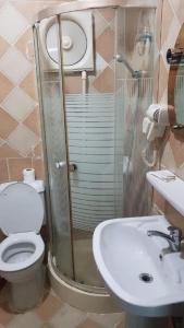 a bathroom with a shower and a toilet and a sink at Al Tawfik Plaza in Makkah