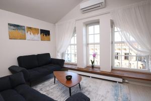 uma sala de estar com um sofá e uma mesa em Bright attic flat in the centre em Riga