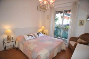 a bedroom with a bed and a window and a chandelier at Lavande de Croisette in Cannes