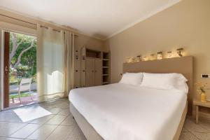 A bed or beds in a room at Hotel Cernia Isola Botanica