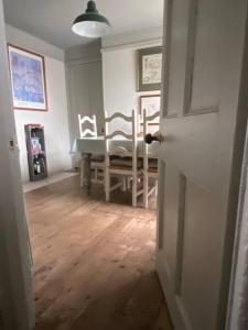 una stanza con tavolo, sedie e porta di Quirky Victorian Cottage in Shaldon Devon a Shaldon