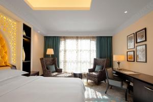 Habitación de hotel con cama, escritorio y sillas en Sheraton Sharjah Beach Resort and Spa, en Sharjah
