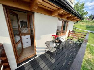 a deck with chairs and a bench on a house at Domek Olczyski in Zakopane