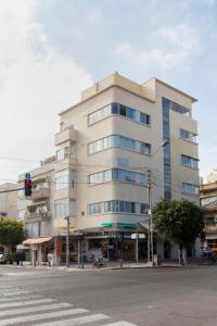 um edifício alto numa rua da cidade com um semáforo em Modern 1BR in Dizengoff by Holiday-rentals em Tel Aviv