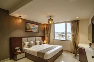 a bedroom with a large bed and a large window at THE MANGAL VIEW RESIDENCY - A Luxury Boutique Business Hotel in Udaipur