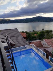 a swimming pool on top of a building with a view of a lake at Casa Clau Cazare Orșova in Orşova