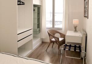 1 dormitorio con escritorio, silla y cama en Les Appartements de Cyrano, en Bergerac