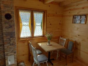 a dining room with a table and chairs and a window at Riverland Cottage 1 in Kolašin