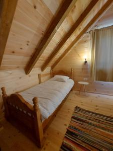 a bedroom with a bed in a wooden attic at Riverland Cottage 1 in Kolašin