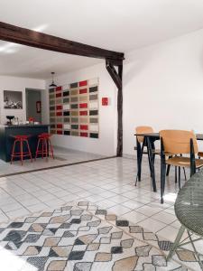 una camera con tavolo e sedie su un pavimento piastrellato di Au nom de la rose, beau 3 pièces en centre-ville a Provins
