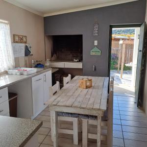 een keuken met een houten tafel en een tafel en stoelen bij Karoo-rus in Montagu