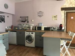 eine Küche mit einer Waschmaschine und einem Geschirrspüler in der Unterkunft La Maison De La Tour Annex in La Sauvetat-du-Dropt